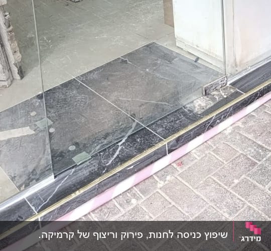 עבודת ריצוף מפתן כניסה באריחים כהים לצד דלת זכוכית